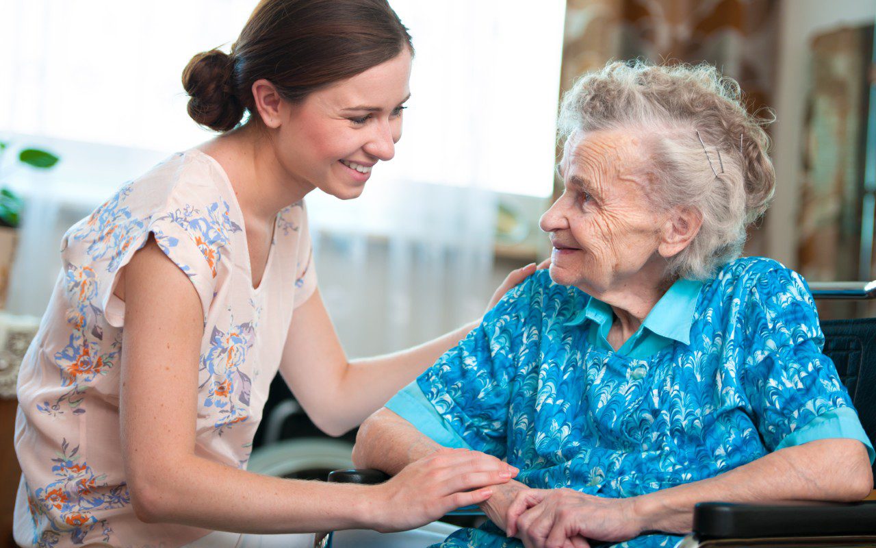 GettyImages-467579823 Young woman comforting elderly woman in wheelchair.
